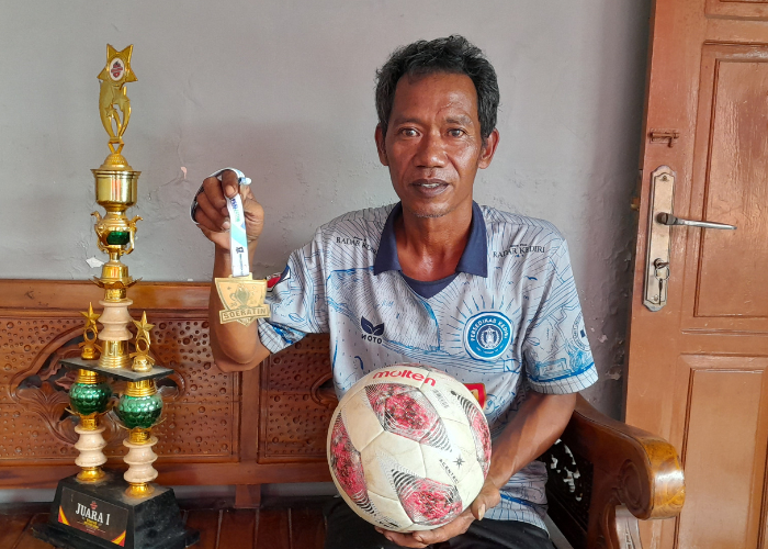JEJAK PRESTASI: Mursalim menunjukkan piala dan medali yang diraihnya dari berbagai ajang kejuaraan sepak bola.