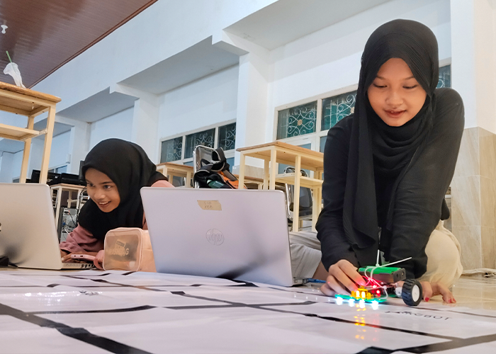 Zahra dan Naufal menunjukkan piagam dan medali lomba robotik tingkat Jatim. Foto kanan, Zahra dan Anggi berlatih mengoperasikan robot line follower di sirkuit lab komputer MTsN 5 Kediri.