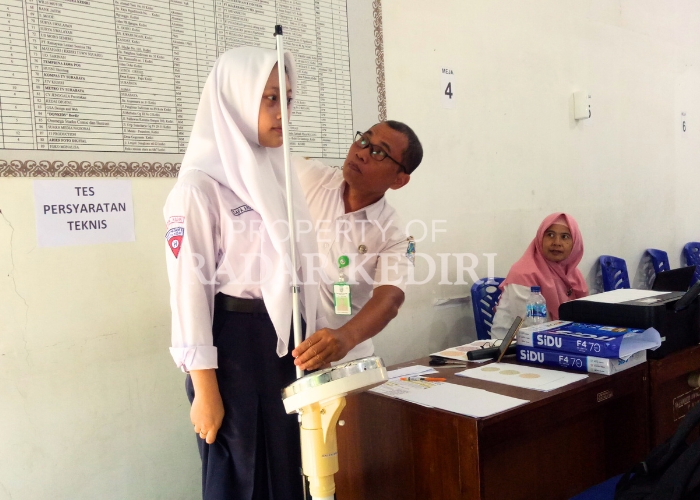 PENUHI SYARAT: Pegawai SMKN 2 Kota Kediri mengukur tinggi badan pendaftar usai melakukan verifikasi berkas kemarin.