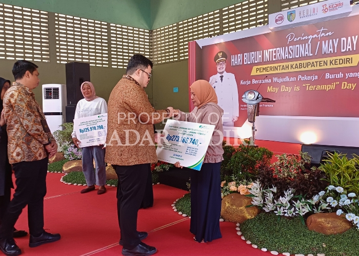SERAHKAN HAK: Bupati Hanindhito Himawan Pramana menyerahkan santunan kepada keluarga pekerja peserta BPJS Ketenagakerjaan di acara peringatan Hari Buruh kemarin.