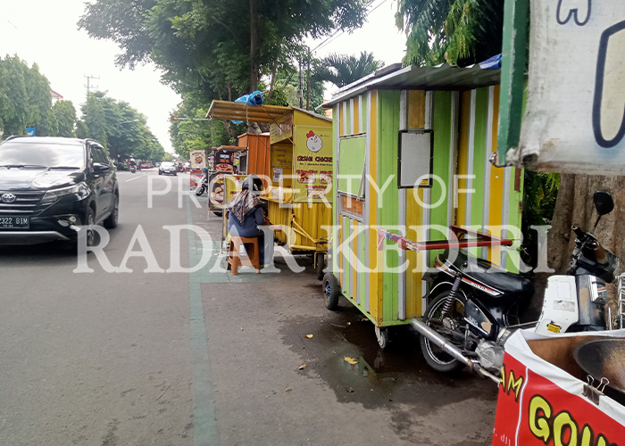 TERGUSUR: Gerobak PKL memadati marka jalan sepeda di Mojoroto.