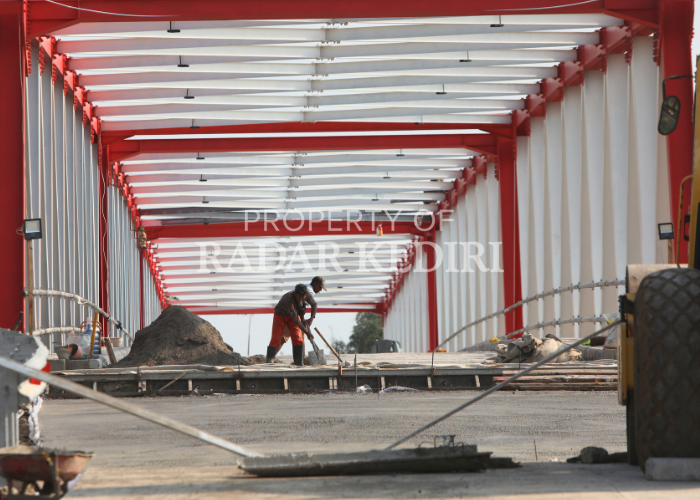 KEBUT PENGERJAAN: Seorang pekerja proyek Jembatan Jongbiru-Mrican sedang merampungkan tahap finishing kemarin.