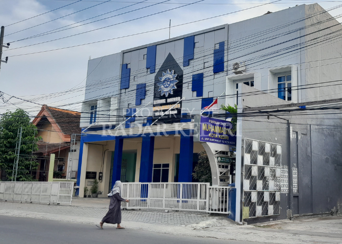 TARIK DANA DI BSI: Seorang warga menyebrang jalan di depan kantor Pimpinan Daerah Muhammadiyah Kota Kediri di Jalan Urip Sumoharjo, Kelurahan Ngronggo, Kecamatan Kota