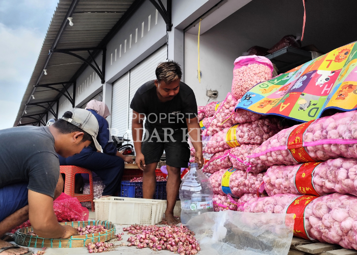 SEPI PEMBELI: Pedagang bawang di Pasar Ngronggo sedang membersihkan brambang tercecer di depan lapak. Mereka mengeluh omzet alami penurunan setelah Pemkot Kediri melakukan relokasi