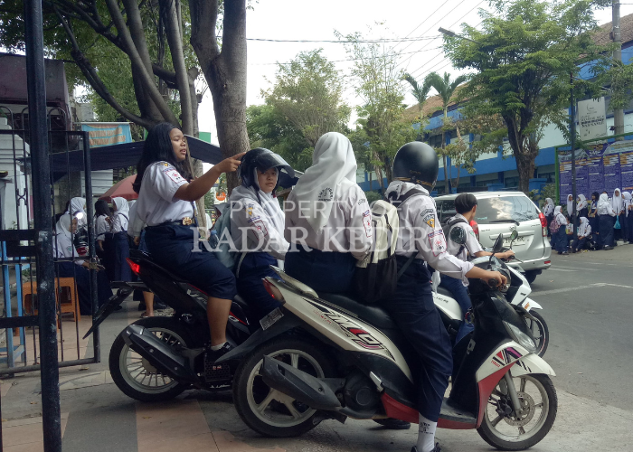 NEKAT: Siswi SMP di Kota Kediri tidak mengenakan helm saat membawa sepeda motor ke sekolah.
