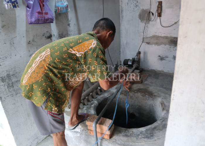 BELUM BERSIH: Sugiono, warga terdampak pencemaran minyak di Kelurahan Tempurejo, Kecamatan Pesantren mengecek kondisi sumurnya yang hingga kemarin masih berbau minyak.