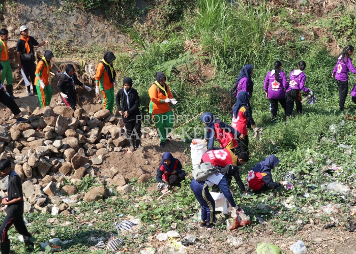 KOTOR: Relawan aksi bersih-bersih sungai mengambil sampah yang menumpuk di Sungai Kedak kemarin (27/7).