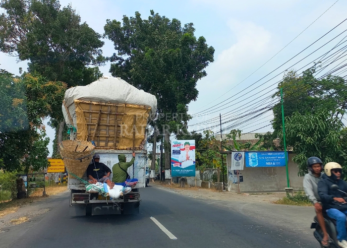 BERBAHAYA: Truk mengangkut sekam padi melebihi kapasitas serta membawa dua orang tanpa pengaman di belakang bak melintas di Desa Blabak, Kecamatan Kandat kemarin.