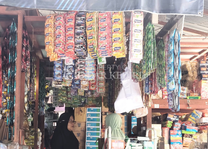 HARGA MELONJAK: Pedagang di Pasar Bandar melayani pembeli di lapaknya. Saat ini, harga biji kopi yang dijual mengalami kenaikan hingga Rp 95 ribu per kilogram.