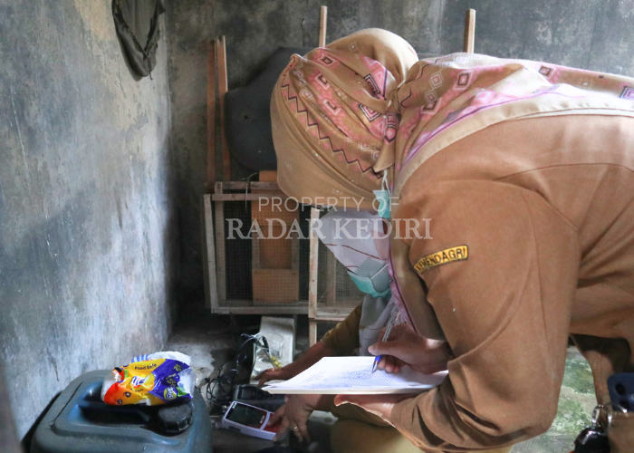 MASIH TERCEMAR: Petugas Labkesda Kota Kediri mencatat hasil uji sampel air sumur di Keluatahan Tempurejo, Kecamatan Pesantren.