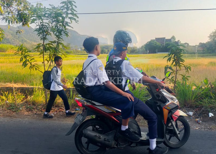 STOP: Polisi menghentikan dua pelajar yang tidak mengenakan helm saat hendak berangkat ke sekolah.