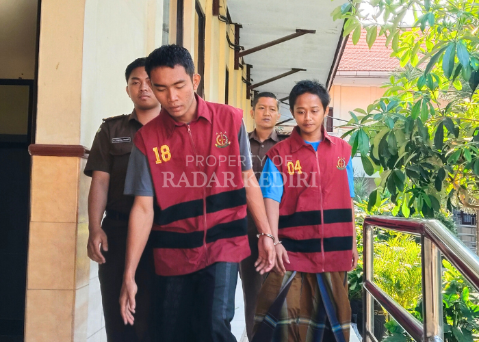 MINTA KERINGANAN: Aisy dan Nasril melangkah ke ruang tahanan sementara setelah sidang di PN Kediri