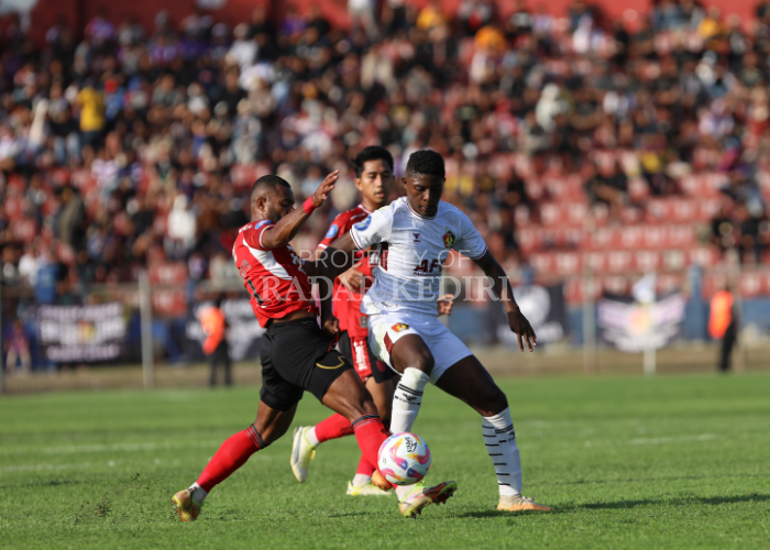SENGIT: Hugo Samir (kanan) berduel dengan pemain bertahan Bali United FC pada laga Liga 1 Indonesia di Stadion Brawijaya Kota Kediri.