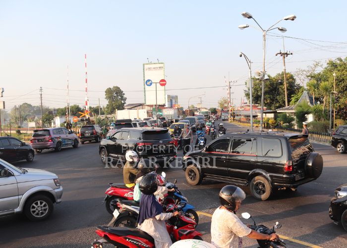 LIBUR PANJANG Polisi di Pos Mengkreng mengatur lalu lintas kendaraan yang mengalami penumpukan di Perempatan Mengkreng Kediri pada Minggu (11/8).