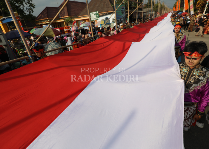 PUPUK NASIONALISME: Ribuan warga Desa Dawung, Ringinrejo, Kabupaten Kediri membentangkan merah putih sepanjang seribu meter sebelum dipasang memanjang di depan Balai Desa Dawung dalam rangkaian pering