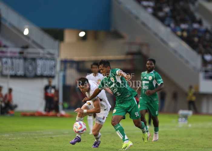 PECAH TELUR: Striker Persik Kediri Ramiro Fergonzi (putih) berduel dengan pemain PSS Sleman di Stadion Manahan Solo kemarin sore. Fergonzi berhasil mencegak satu gol dalam laga ini.