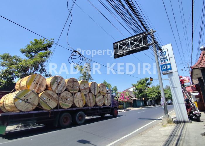 SEMRAWUT Mobil mengangkut kabel melintas di Jalan Gatot Subroto, Kelurahan Mrican, Kecamatan Mojoroto. Kabel yang ditabrak truk tebu masih melingkar di atas jalan raya.