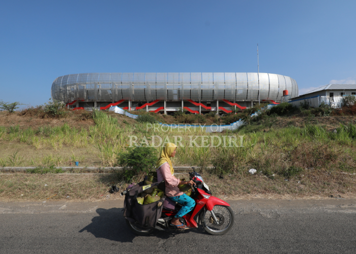 TUNGGU TAHAP II: Warga me lintas di de pan proyek Stadion Ge lora Daha Ja yati di Desa Bulusari, Tarokan. Akhir Septem ber nanti pemba ngunan lan jutan oleh Ke menterian PUPR diharapkan sudah dimulai.