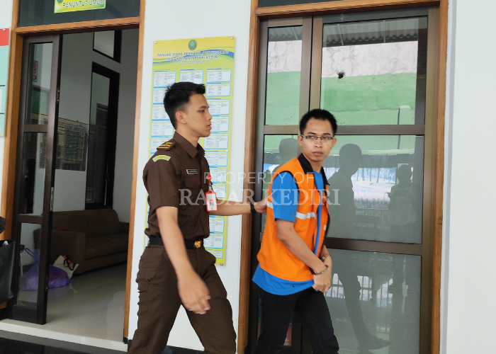 TEGANG: Terdakwa M. Fikri dikawal petugas Kejaksaan di PN Kota Kediri.
