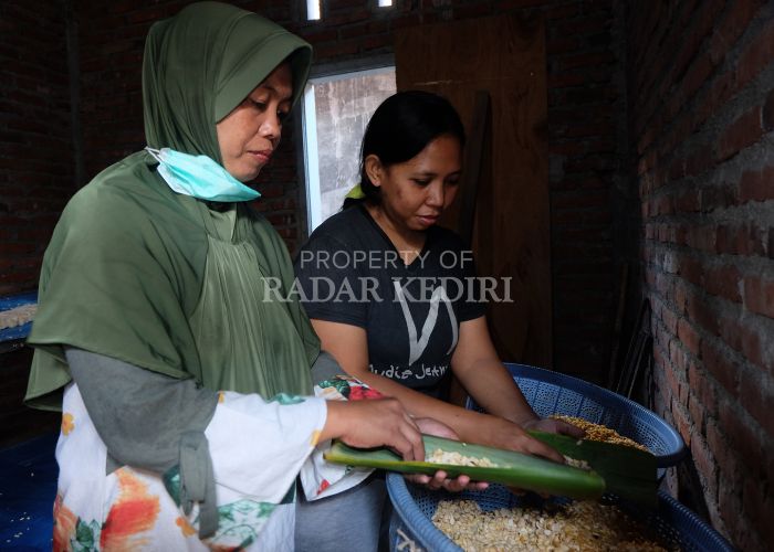 TURUN-TEMURUN: Muningsih (berkerudung) bersama Dwi Lailina sedang mengemas olahan tempe di rumahnya di Desa Wonokerto, Plemahan kemarin (20/3).