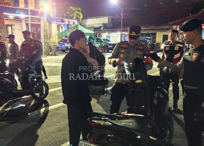 GELAR RAZIA: Kasatreskrim Polres Kediri Kota AKP Fathur Rozikin memeriksa barang bawaan pengendara motor di halaman Satlantas.