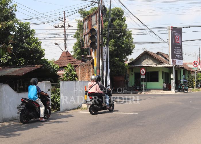 BERBAHAYA Pengendara bermotor saat menerobos perempatan yang traffic light-nya tidak berfungsi dengan baik.