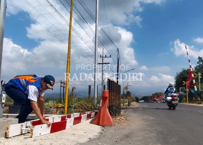 PATAH Petugas Jaga Palang Pintu KA Branggahan, Ngadiluwih  memperhatikan palang pintu yang rusak setelah di tabrak pemotor asal Banyakan