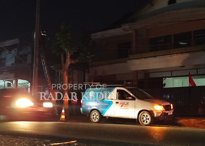 PADAM Petugas PLN membenahi kabel sekaligus listrik warga yang padam setelah insiden tabrakan truk muatan sekam.