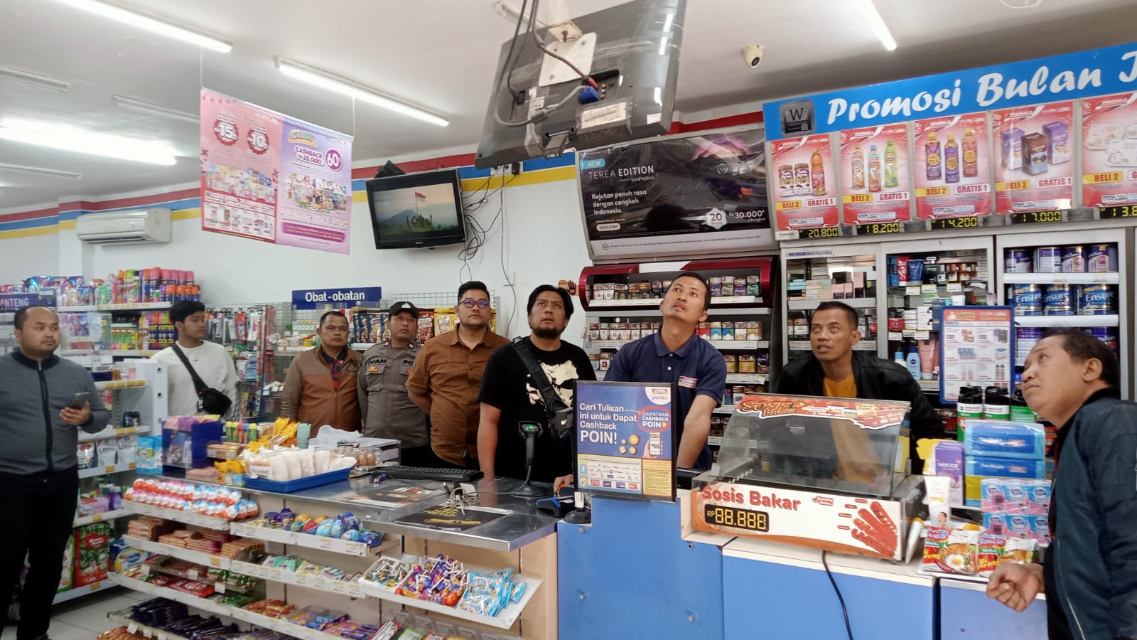 MENGERIKAN Kasat Reskrim Polres Kediri Kota Iptu M Fathur Rozikin bersama anggotanya memerhatikan rekaman CCTV di Indomaret Raung setelah kejadian.