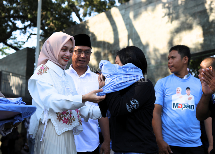 BERI DUKUNGAN: Vinanda Prames wati dan Gus Qowi muddin Thoha memakaikan kaus kepada sejumlah pemuda dalam dekralasi dukungan dari Koalisi Pemuda Kota Kediri di Memorial Park kemarin.