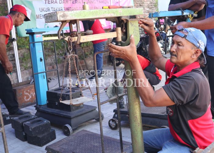 TAK AKURAT Teknisi timbangan saat melakukan pengecekan alat ukur lama yang dipakai pedagang Pasar Ngronggo
