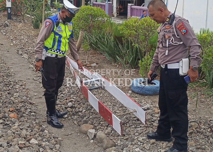 RUSAK: Petugas kepolisian  meninjau lokasi kejadian usai peristiwa penabrakan palang pintu perlintasan KA di Kelurahan Setonopande pada Selasa (10/9).