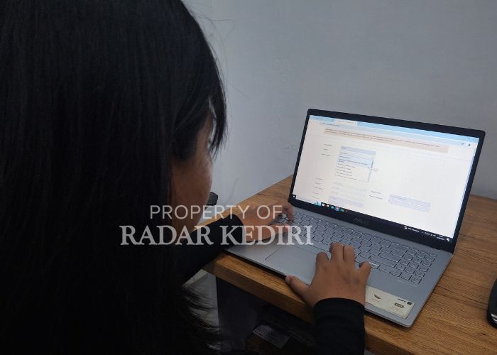 SERIUS: Seorang warga membuka website seleksi CPNS Kabupaten Kediri
