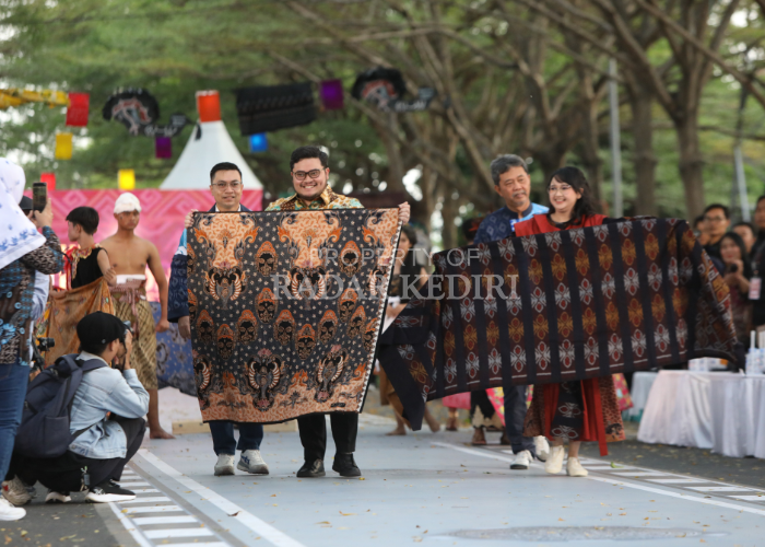 WAHYU ADJI/JPRK CORAK KHAS: Bupati Kediri Hanindhito dan istrinya, Cicha, membentangkan batik Panji dan tenun Wikara dengan berjalan di catwalk KFBF 2024 di Taman Hijau SLG.