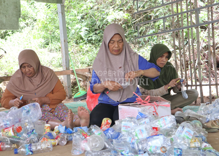 SELAMATKAN LINGKUNGAN: Sejumlah ibu-ibu anggota Bank Sampah Paguyuban Sukowono Irenggolo memilah sampah botol dalam pertemuan bank sampah Jumat (13/9).