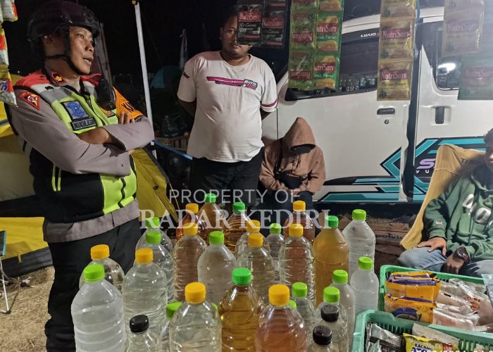 TINDAK TEGAS: Kabag Ops Polres Kediri Kota Kompol Mukhlason menyita minuman keras (miras) jenis arak dan ciu yang dijual bebas di kawasan GOR Joyoboyo saat kegiatan masyarakat sedang berlangsung.