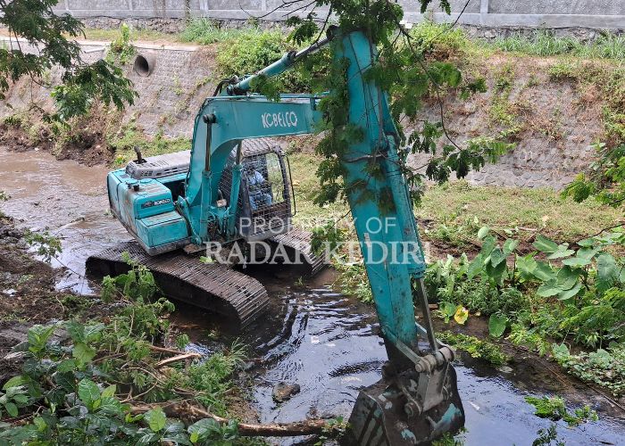 DIKERUK: Satu unit alat berat melakukan pengerukan di sungai Kalasan, di sekitar Taman Hijau SLG, Kabupaten Kediri.