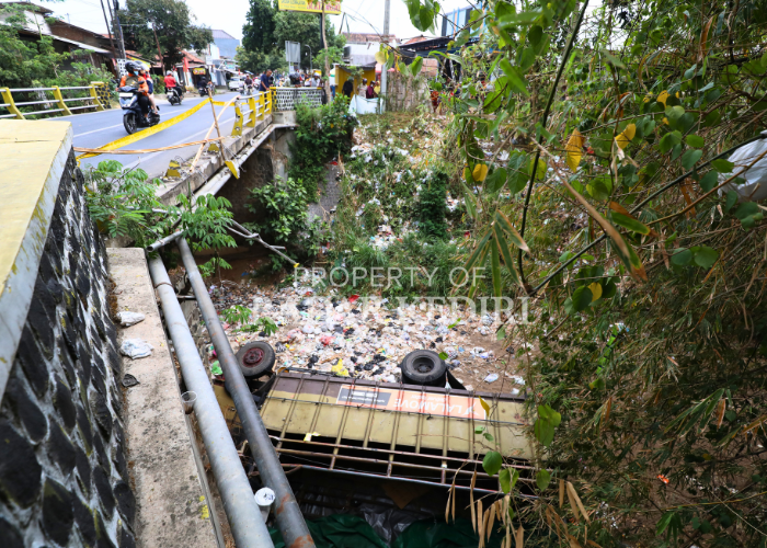 KECELAKAAN TUNGGAL: Truk bermuatan snack jatuh ke sungai di Jembatan Brenggolo, Mojo setelah oleng akibat menghindari sepeda listrik yang menyalip. Foto kiri, Sejumlah mobil derek bersiap mengevakuasi