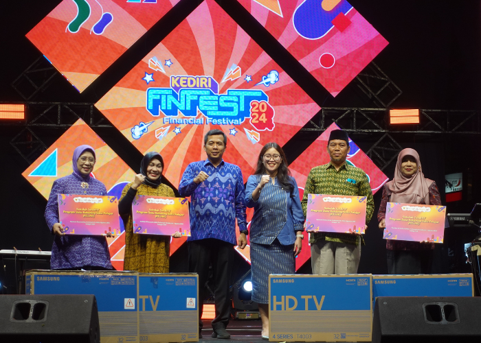 BERI APRESIASI- Kepala OJK Kediri Ismirani Saputri (tengah) menyerahkan hadiah penghargaan bagi sekorah teraktif satu pelajar satu rekening tingkat SD dan SMP.
