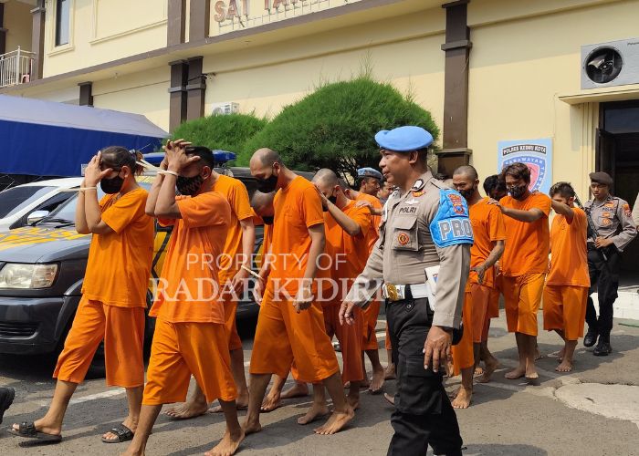 MASUK BUI: 14 tersangka narkoba dijaga ketat anggota polisi saat berjalan menuju ruang untuk rilis kasus tumpas narkoba di Polres Kediri Kota pada Senin (24/9).
