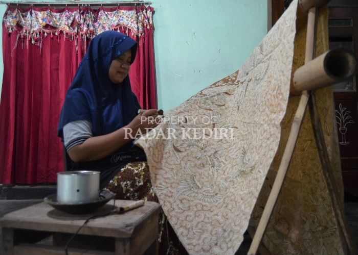 TEKUN: Wiwin Munawaroh mencanting kain untuk batik dengan pewarna alami.