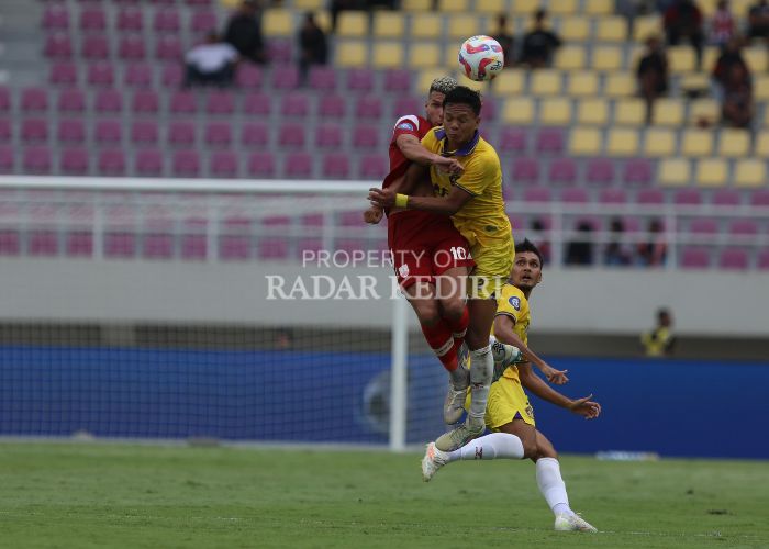 TERBANG: Dede Sapari beradu sundulan dengan pemain Persi Solo saat pertandingan di Stadion Manahan, Senin (23/9) kemarin.