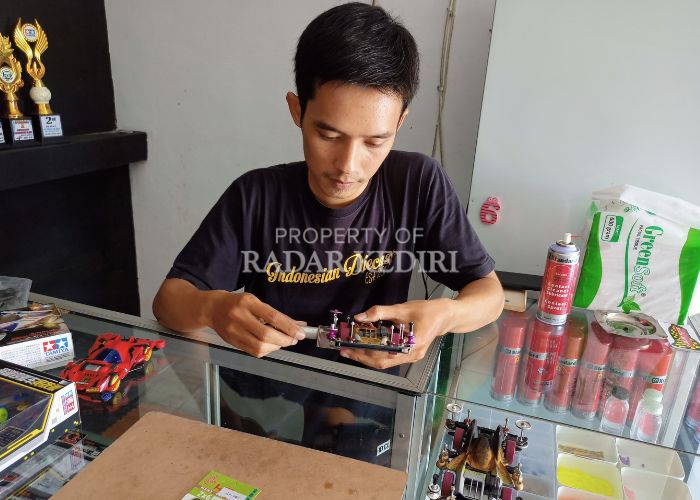 TELITI: Ferri menyervis mobil tamiya di toko miliknya di Desa Ngablak, Banyakan.