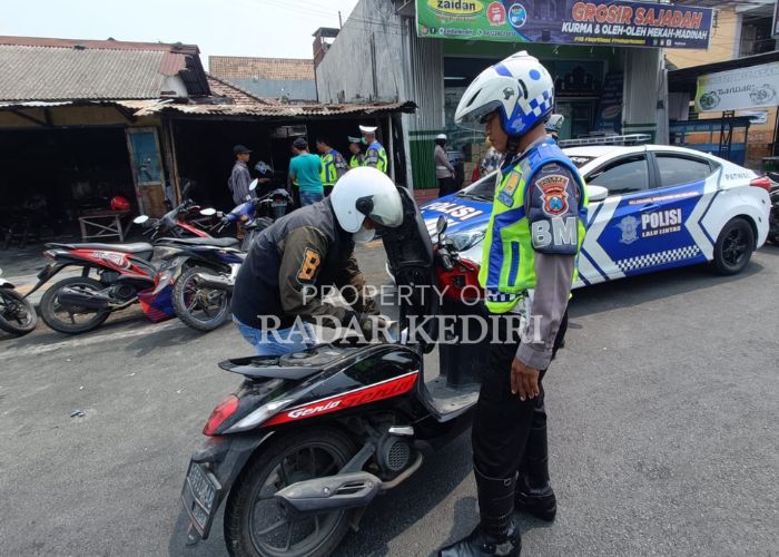 CEK KELENGKAPAN: Pengedara motor membuka jok saat pemeriksaan surat-surat kendaraan.