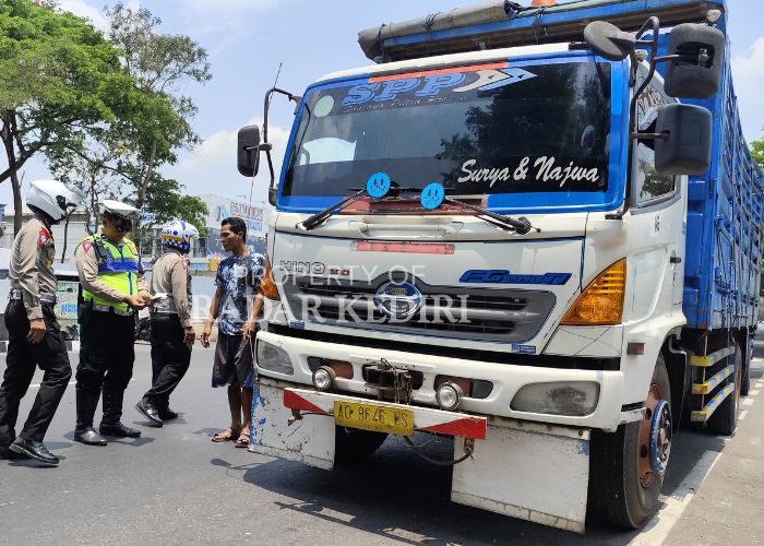 TINDAK TEGAS: Polisi memeriksa kelengkapan surat kendaraan yang dibawa sopir truk.