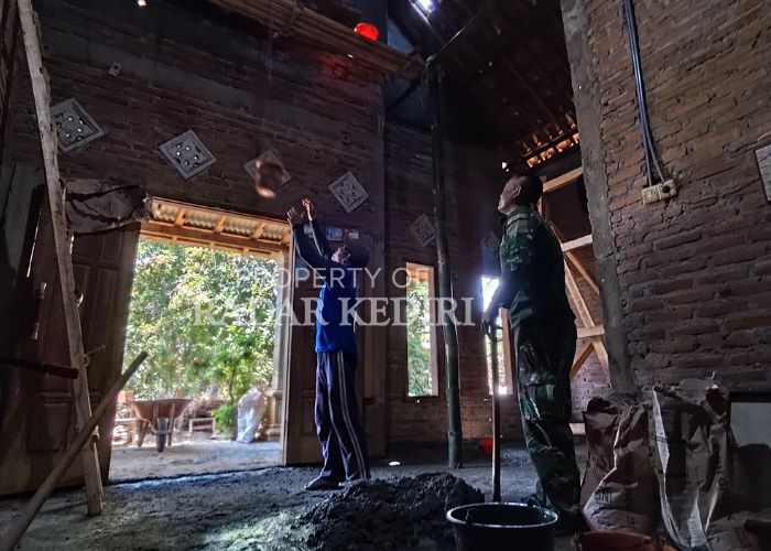 KERJA KERAS: Anggota TNI dan pekerja memasukan semen ke dalam ember untuk plester rumah di Desa Pagung, Kecamatan Semen, Kabupaten Kediri.