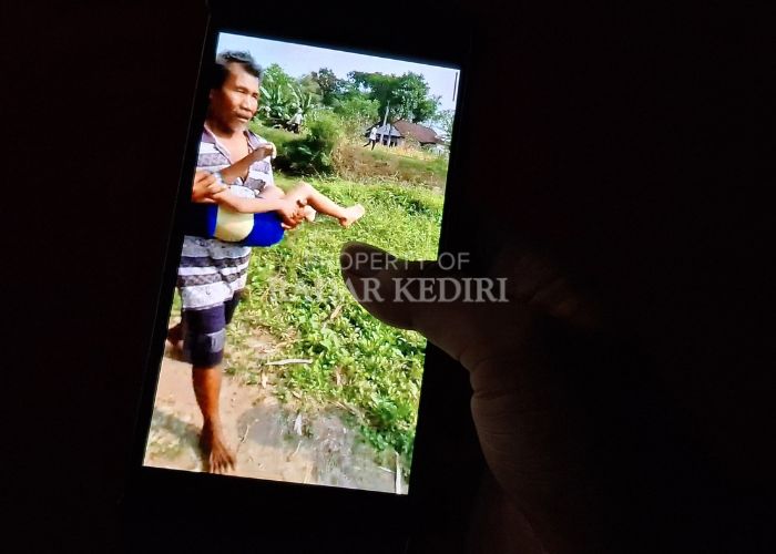 MEMILUKAN: Salah seorang warga melihat video evakuasi dua bocah TK yang tewas tenggelam di Plemahan, Kediri.