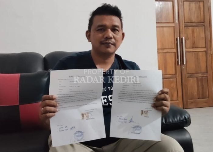 PASRAH: Kepala Desa Mojoayu Yosi menunjukkan surat pernyataan dari keluarga kedua korban tenggelam.