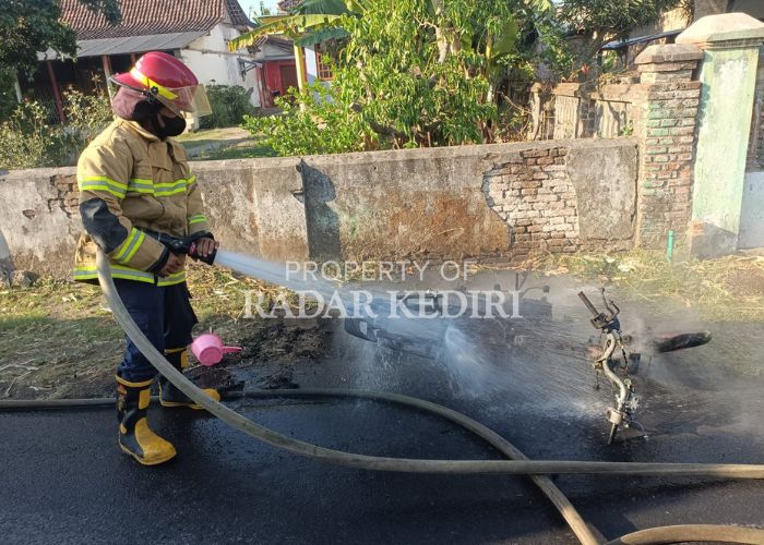 HANGUS: Petugas pemadam kebakaran menyemprotkan air ke sepeda motor Yamaha FIZ R  yang terbakar.