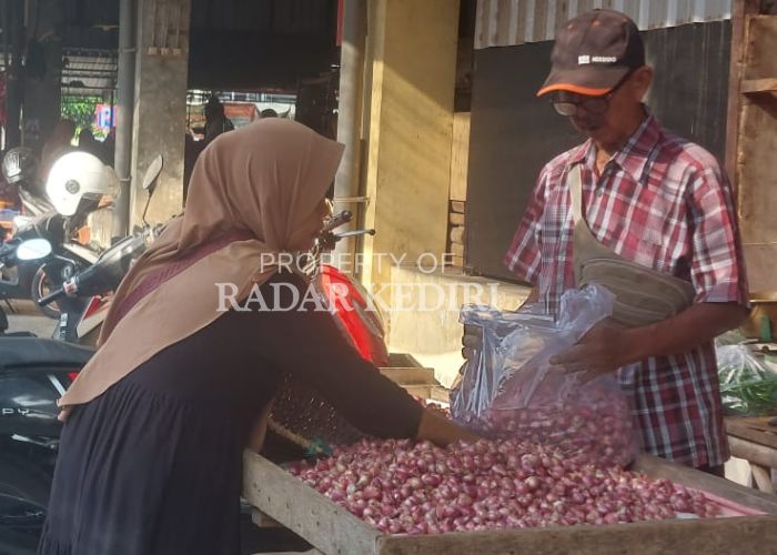 ANJLOK: Pedagang bawang merah Pasar Induk Pare Kediri melayani pembeli.